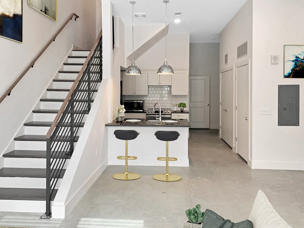 a kitchen with an island and a staircase in a house