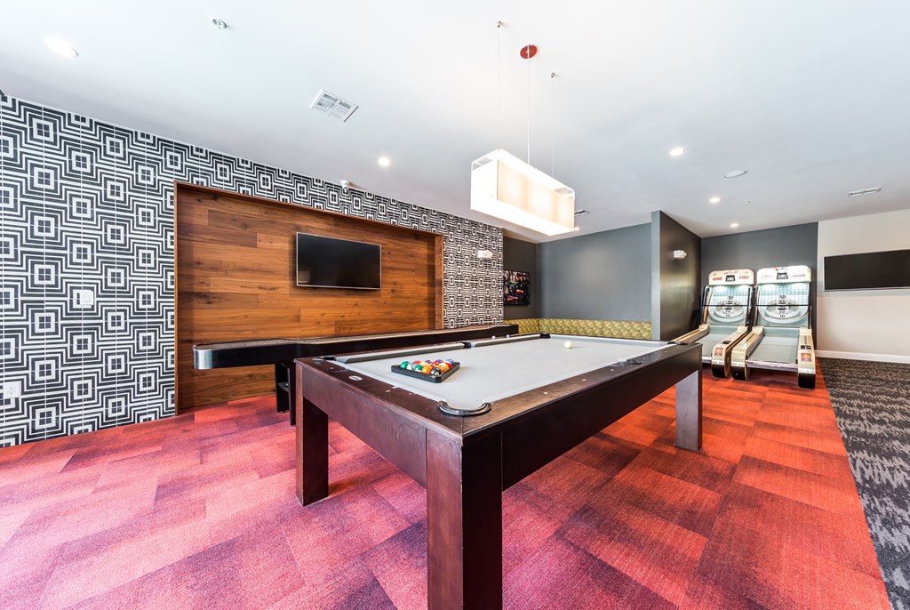 a game room with a pool table and a tv