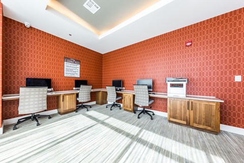 a conference room with desks and chairs and orange wallpaper