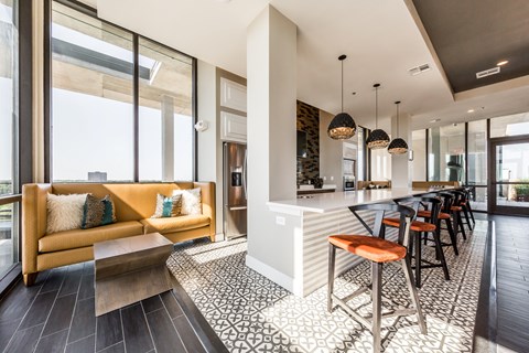 a living room with a kitchen and a bar with stools