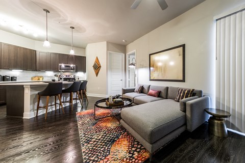 a living room and kitchen with a couch and a table