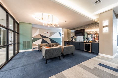 a living room with couches and chairs and a wall with a geometric design