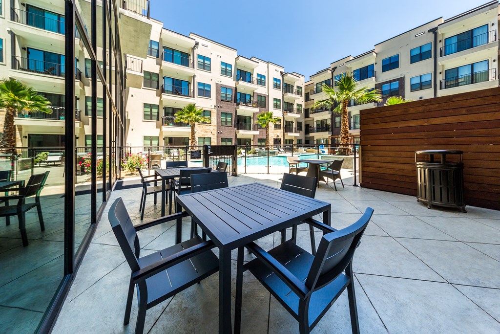 private patio with tables and chairs at the cardinal apartments worth