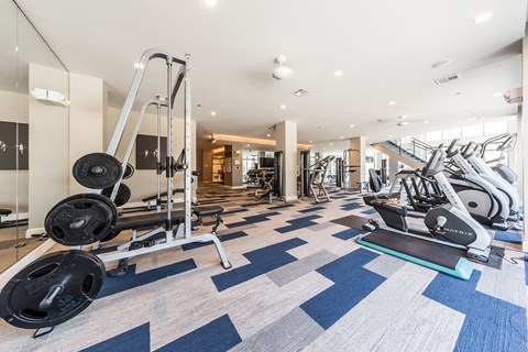a gym with cardio machines and weights on the floor