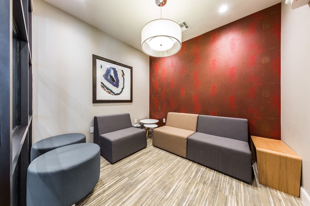 a living room with couches and chairs and a red wall