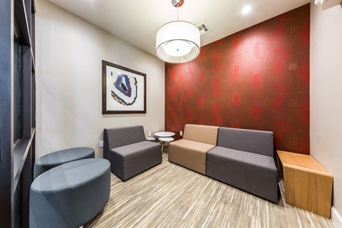 a living room with couches and chairs and a red wall