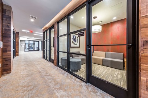 a hallway with glass doors and furniture in a building