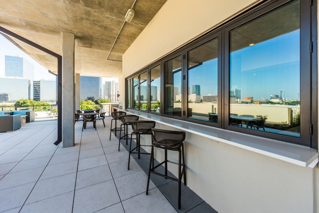 a balcony with bar stools and a view of the city