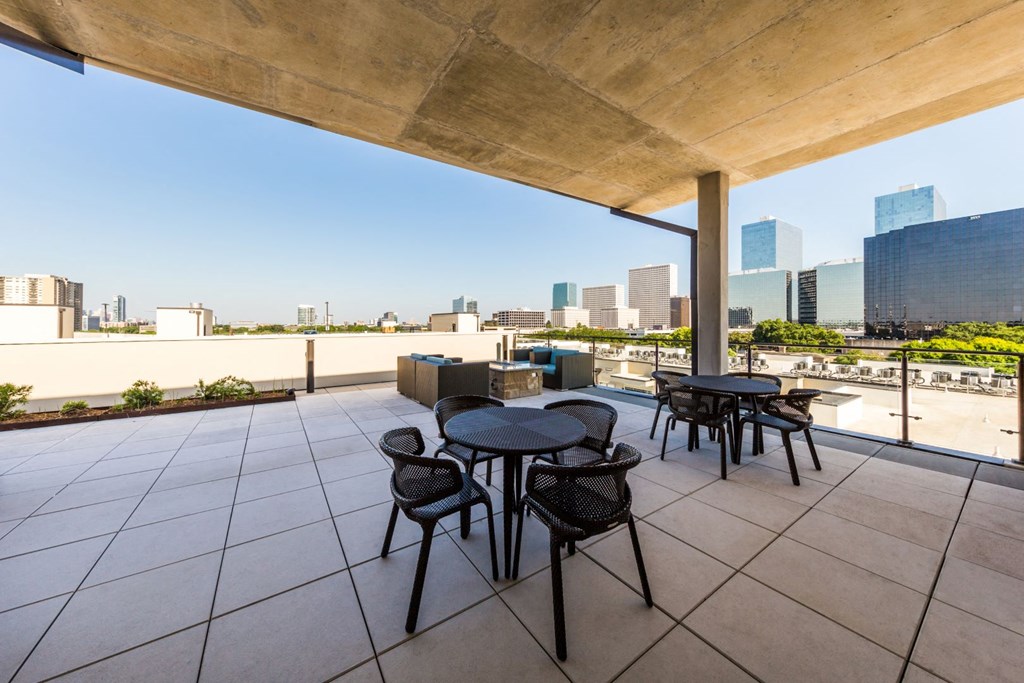 rooftop terrace with tables and chairs and a view of the city