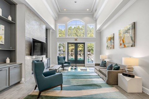 A living room with a blue rug and a green chair.
