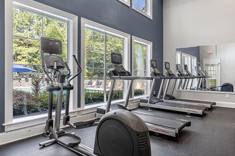 A gym with treadmills, elliptical machines, and a stationary bike.