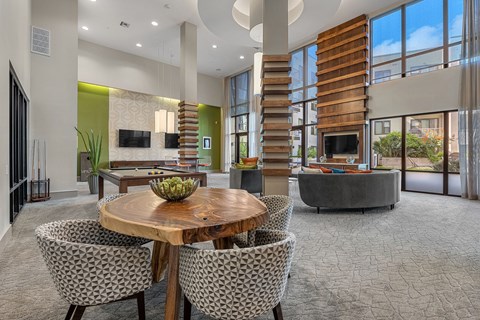 A modern dining room with a round wooden table and chairs.