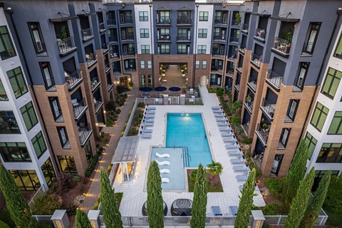 an overhead view of an apartment building with a swimming pool