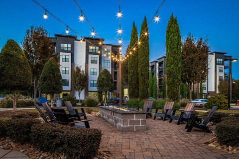 a courtyard with benches and a fire pit at night