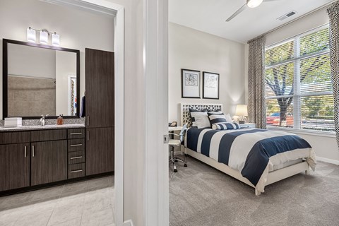 a bedroom with a bed and a vanity with a mirror