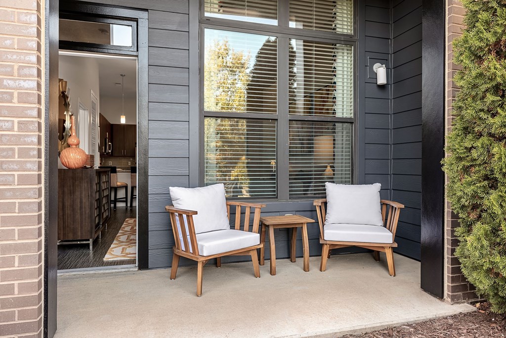 a patio with two chairs and a table and a window