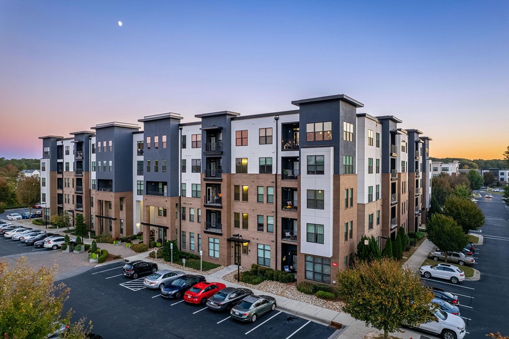 an aerial view of an apartment building with a parking lot