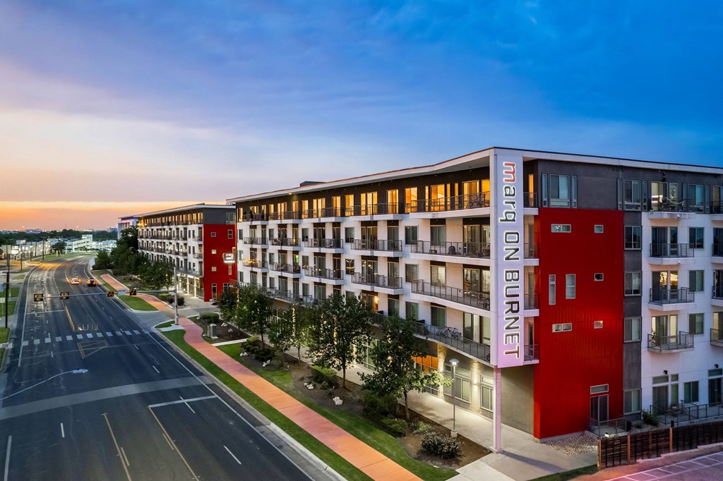 an apartment building with a street in front of it