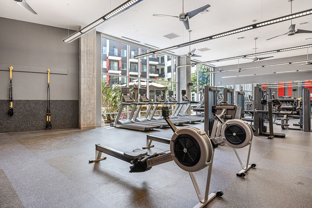 a gym with weights machines and a large window