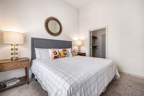 a bedroom with a large bed and a mirror