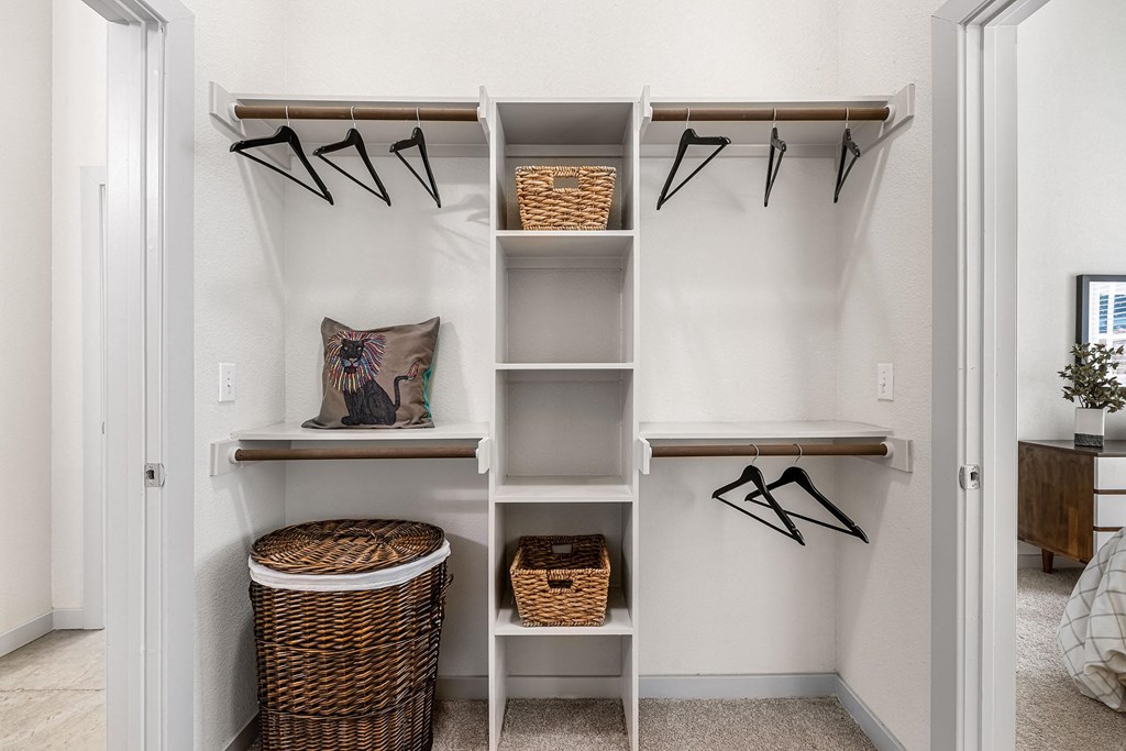 a closet with shelves and baskets and hangers on the wall