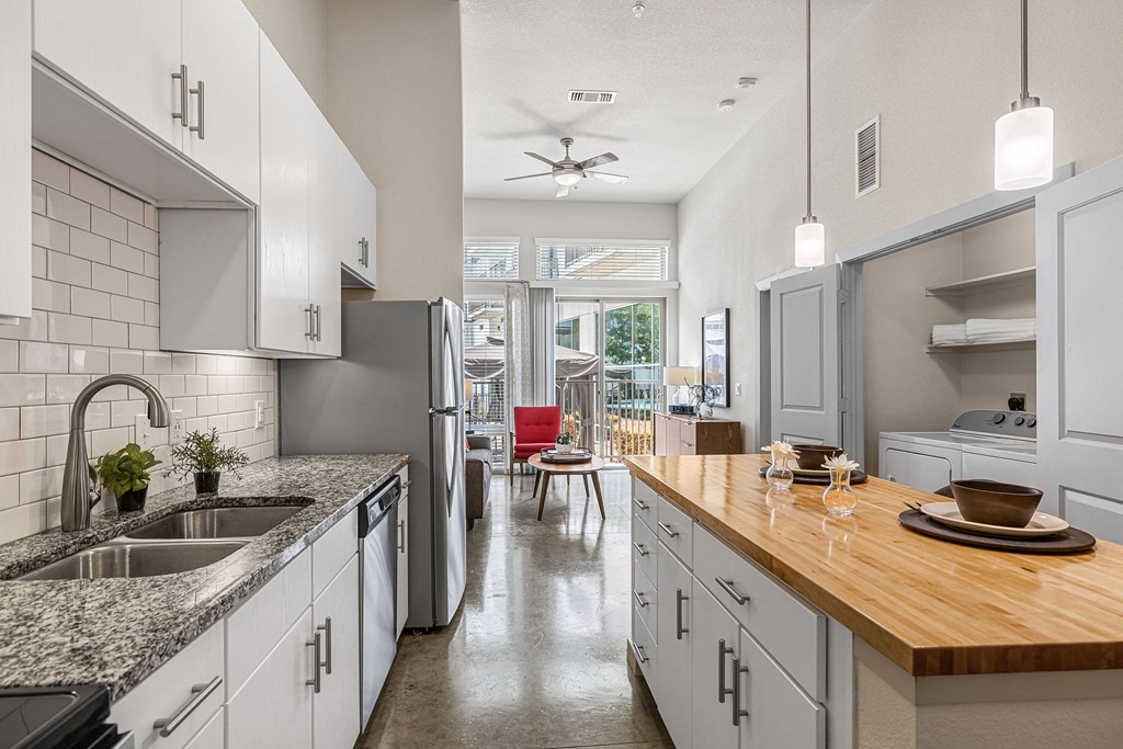 a kitchen with white cabinets and a wooden counter top