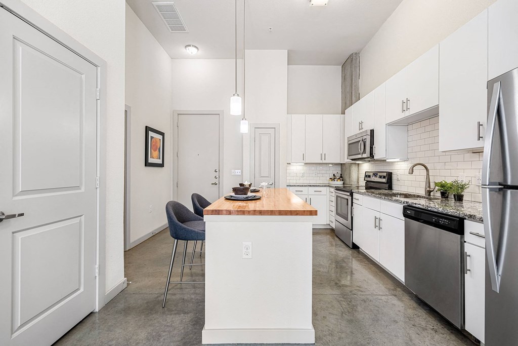 a kitchen with white cabinets and stainless steel appliances