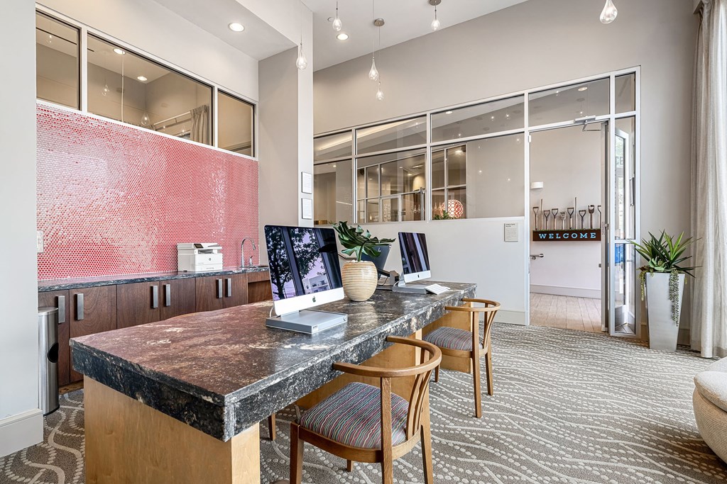 an office with a granite desk and chairs and a large window