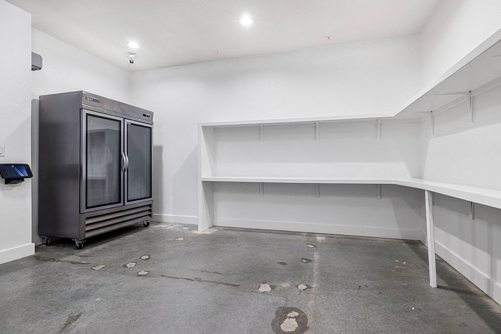 the interior of a room with a refrigerator and white walls