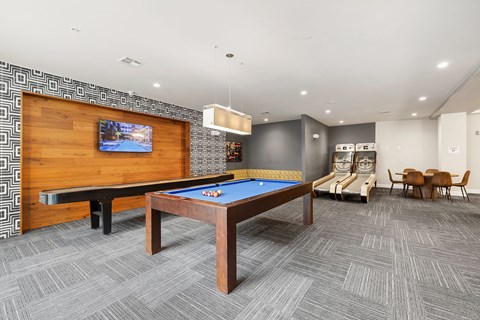 A room with a pool table and a television.