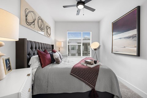 a bedroom with a bed and a ceiling fan