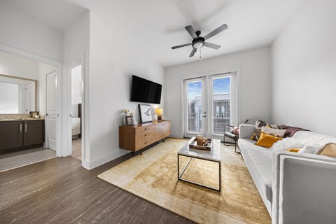 A living room with a white couch and a wooden coffee table.