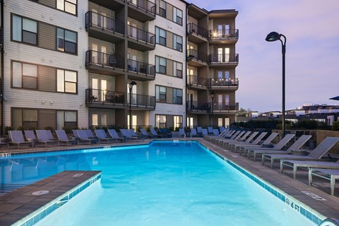 a large swimming pool in front of an apartment building