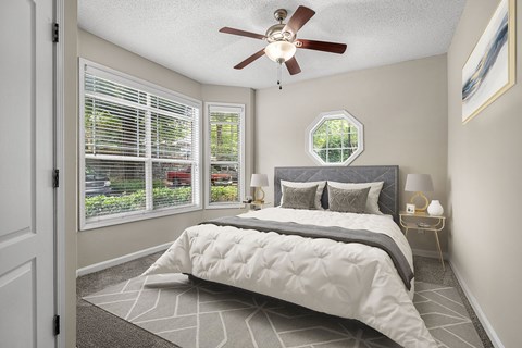 A bedroom with a large bed and a ceiling fan.