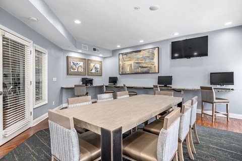 A dining room with a large table and chairs.
