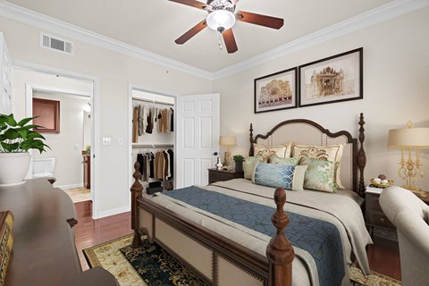A bedroom with a large bed and a ceiling fan.