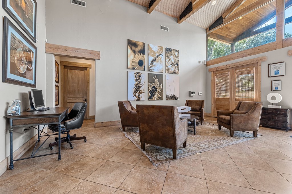 a home office with a desk and chairs and a large window