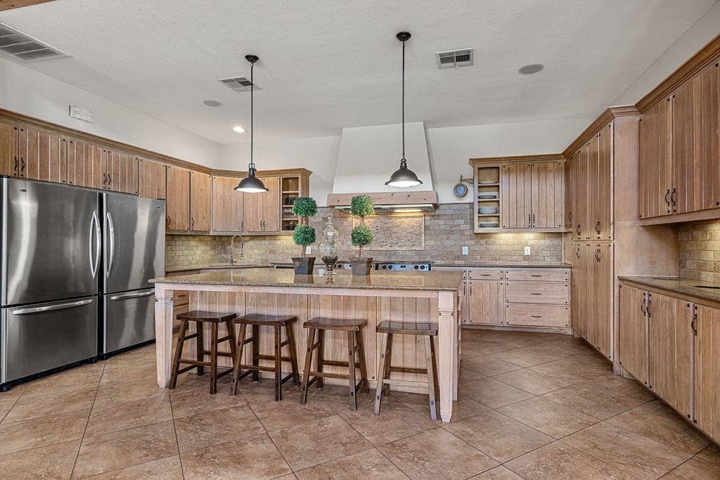 a kitchen with a large island and stainless steel appliances