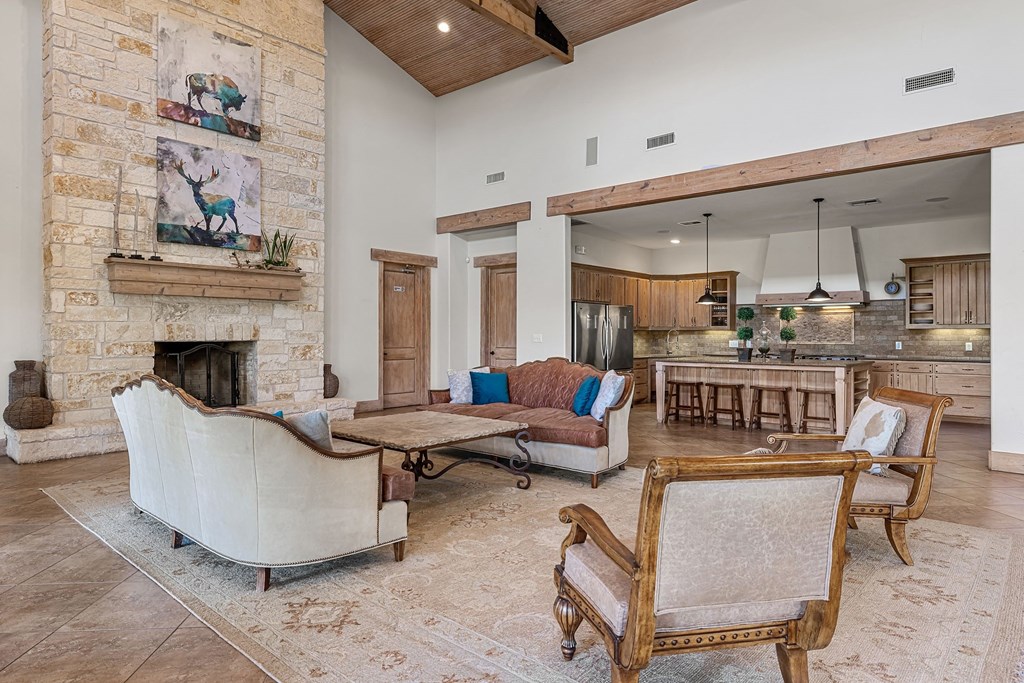 a large living room with a stone fireplace and furniture