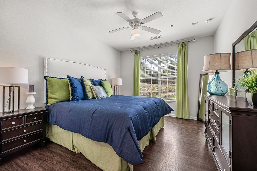a bedroom with a large bed and a ceiling fan