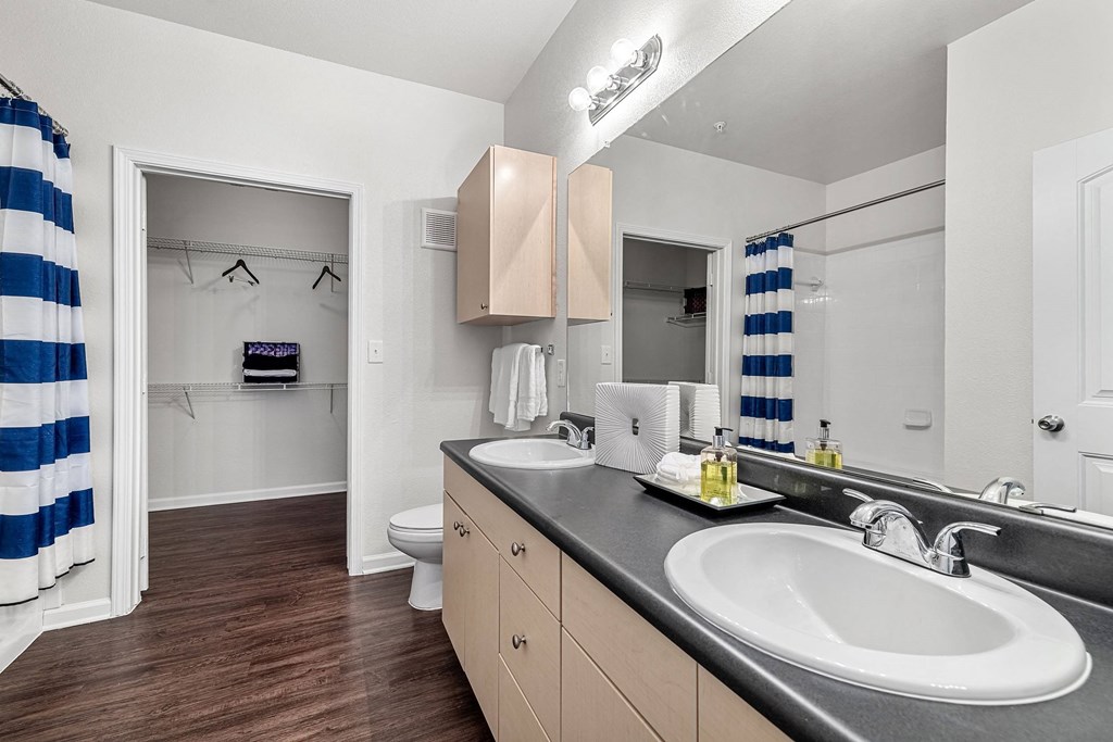 a bathroom with two sinks and a shower and a toilet