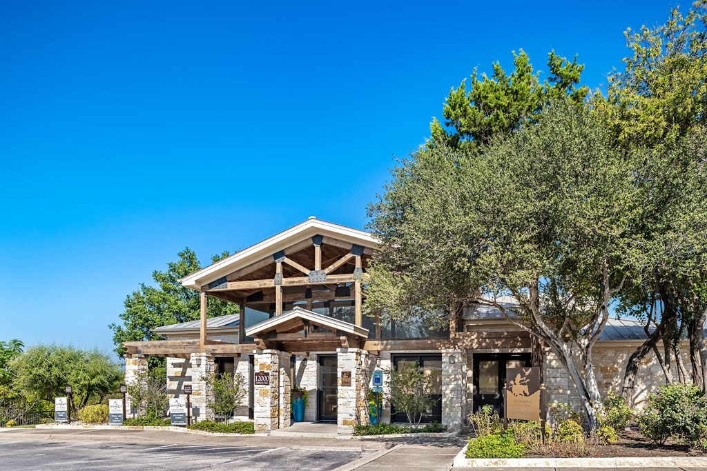 the front of a building with trees and a blue sky