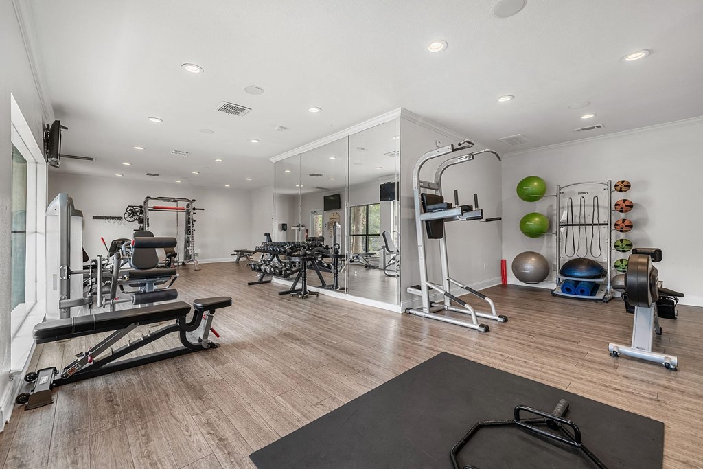 a home gym with exercise equipment and mirrors on the wall