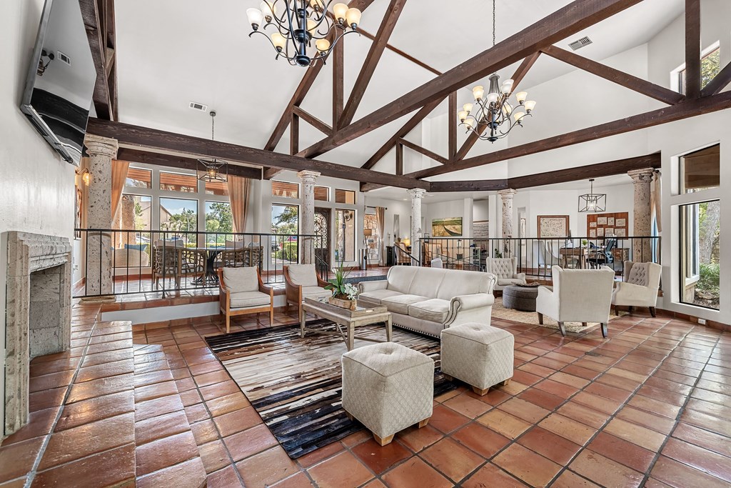 the living room has exposed wood beams and a stone fireplace