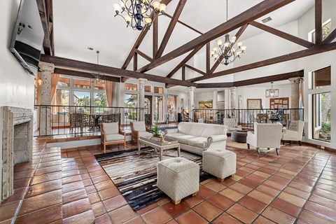 the living room has exposed wood beams and a stone fireplace