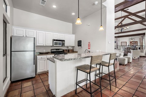 a kitchen with a bar and a stainless steel refrigerator