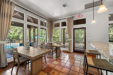 a dining area with a table and chairs and a balcony with a pool