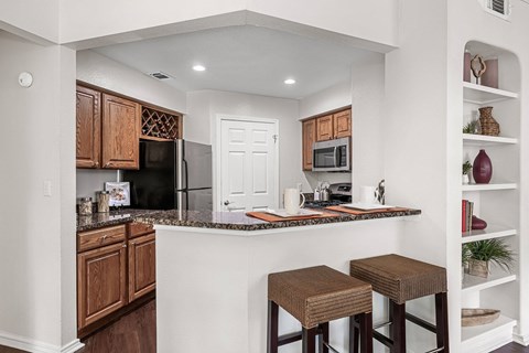a kitchen with a counter top with two stools