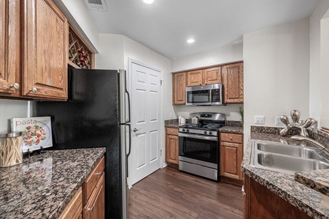 a kitchen with granite counter tops and wooden cabinets