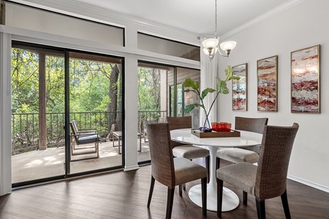 a dining room with a table and chairs and sliding glass doors